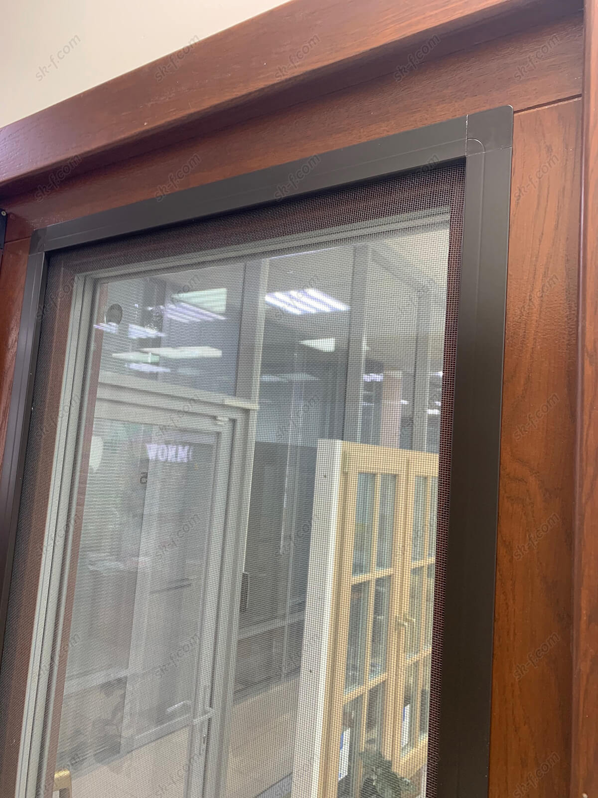 Коричневая москитная сетка на деревянном окне